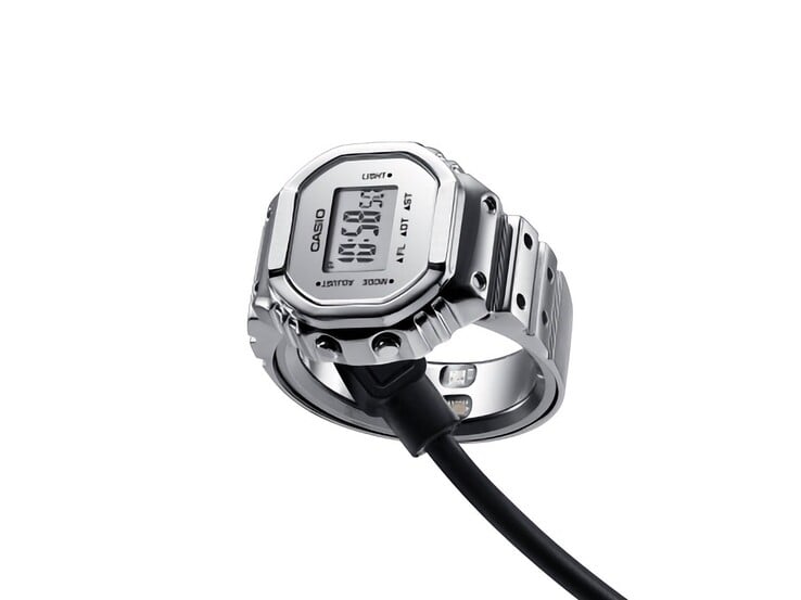 Relógio-anel inteligente Casio CRW-H001M-8 conectado ao seu cabo de carregamento USB magnético.