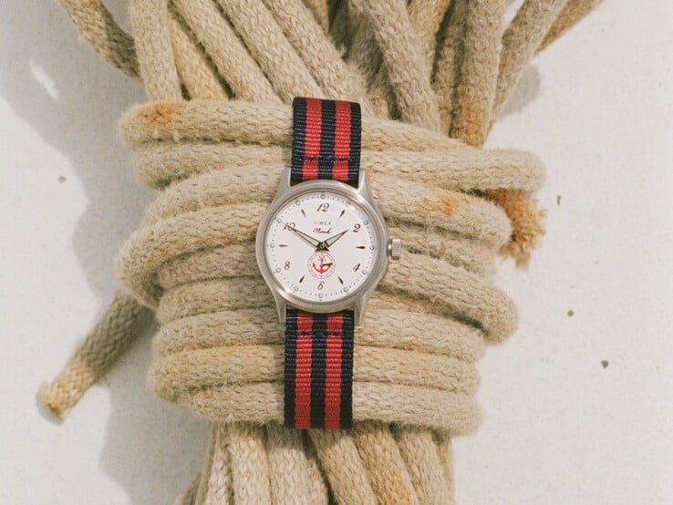 Relógio Noah x Timex MK1 Anchor com caixa prateada de 36 mm, mostrador branco, desenho de âncora e pulseira de tecido listrada em azul-marinho e vermelho.