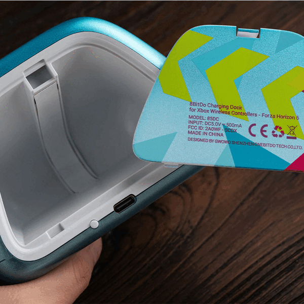 A base de carregamento 8BitDo tem um compartimento de armazenamento para pequenos acessórios para um controle Xbox.