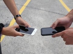 Duas pessoas segurando dois smartphones lado a lado durante uma entrega