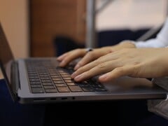 Mãos digitando no teclado de um laptop