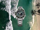Relógio de mergulho Seiko Prospex HBC001 com mostrador e bezel verdes exibidos sobre um fundo aéreo de praia e oceano.