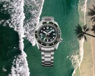 Relógio de mergulho Seiko Prospex HBC001 com mostrador e bezel verdes exibidos sobre um fundo aéreo de praia e oceano.