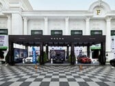 Estande da Volvo na Realestate.com.kh Expo 2022, exibindo vários carros da Volvo, incluindo SUVs, com banners promocionais e marcas em frente a um grande edifício branco com colunas. (Fonte da imagem: I'm Zion via Pexels)
