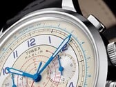 Close-up do mostrador creme do cronógrafo Timex Marlin Neo Classic, com ponteiros azuis e algarismos arábicos, marcações vermelhas do taquímetro e uma escala azul de telemetria ao redor da borda externa.