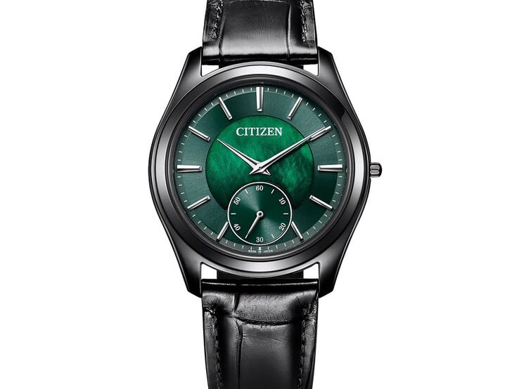 Vista aproximada em ângulo do Citizen Eco-Drive One AQ5025-04N, mostrando seu mostrador verde cintilante de madrepérola, ponteiros e marcadores em tom prateado, caixa preta e pulseira de couro.