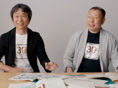 Uma captura de tela de Shigru Miyamoto e Tezuka Takashi usando camisetas do 30º aniversário de Super Mario Bros