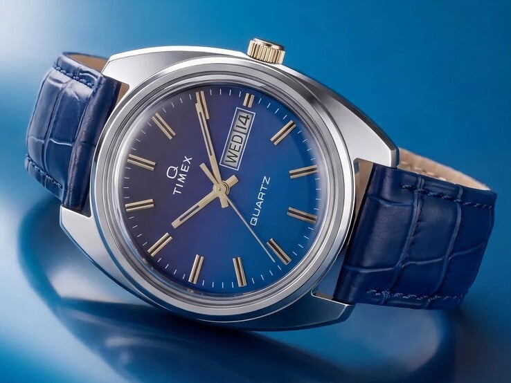Fotografia do Timex Q 1976 Day and Date em ângulo, destacando o mostrador com gradiente azul, a caixa de aço inoxidável polido e a coroa em tom dourado.