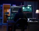 Figura encapuzada em uma configuração de várias telas executando um ataque cibernético.