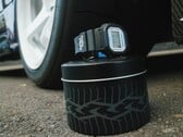 Relógio Casio G-Shock DW5600TT25-1 x Toyo Tires exibido em uma lata de metal com tema de pneu ao lado de uma roda de carro.