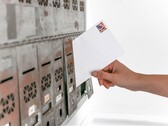 Uma mão colocando um envelope em uma fileira de caixas de correio