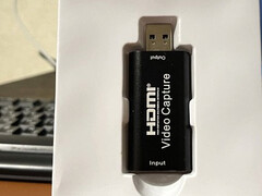 O adaptador, prestes a ser retirado de sua embalagem plástica branca interna (Fonte da imagem: ZachemKupil on MySKU, cortado, cor normalizada)