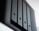 Foto em close-up de um gabinete NAS preto com vários compartimentos para discos rígidos