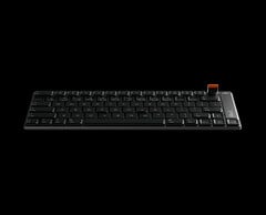 O teclado é usinado por CNC a partir de um único bloco de alumínio e inclui um seletor giratório magnético removível para controle de volume e mídia.