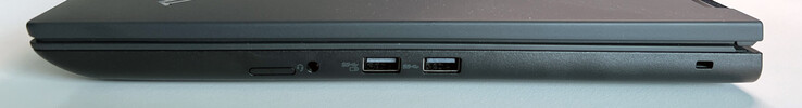 À direita: Slot para cartão SIM (opcional), conector de áudio de 3,5 mm, USB-A 3.2 Gen. 1 (5 GBit/s, alimentado), USB-A 3.2 Gen. 1 (5 GBit/s), slot Kensington