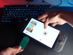 Yu, do canal do YouTube Better Gaming, segurando um Nintendo Switch 2 em uma mão e um adaptador PCB verde de código aberto na outra, tentando inseri-lo no slot microSD Express do dispositivo (Fonte da imagem: Better Gaming via YouTube)