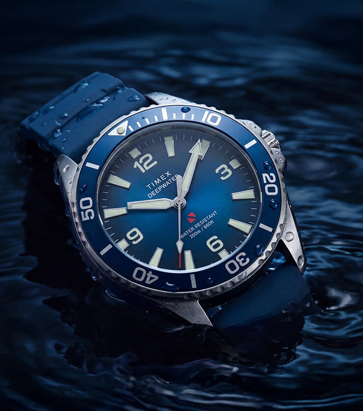 Timex Deepwater Arctic 200 com mostrador azul degradê e pulseira de borracha HNBR azul combinando, fotografado parcialmente submerso na água.