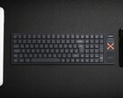 Teclado mecânico sem fio Iqunix Magi96 em uma mesa com outras tecnologias