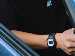 Pessoa usando o relógio Casio G-Shock DW5600TT25-1 x Toyo Tires enquanto está sentada dentro de um carro.