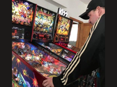 Kim Michael Dozier, colecionador de máquinas de pinball da Nova Zelândia, jogando uma máquina de pinball do Iron Maiden no Kimzone