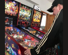 Kim Michael Dozier, colecionador de máquinas de pinball da Nova Zelândia, jogando uma máquina de pinball do Iron Maiden no Kimzone