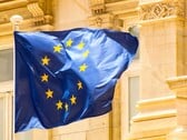 Bandeira da UE hasteada em frente a uma arquitetura histórica