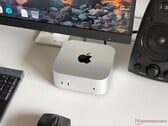 Um Mac mini com chip Apple M6 sobre uma mesa em uma configuração para jogos, com monitor, teclado, mouse e alto-falante.