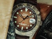 Relógio de mergulho Huckberry x Timex Deepwater Reef 200 com mostrador marrom, caixa em aço inoxidável, luneta preta e pulseira marrom combinando.