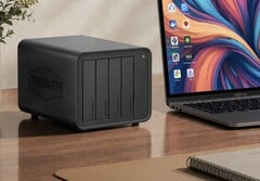A imagem mostra o NAS Terramaster D8 Hybrid 2 ao lado de um laptop sobre uma mesa de madeira