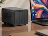 A imagem mostra o NAS Terramaster D8 Hybrid 2 ao lado de um laptop sobre uma mesa de madeira 