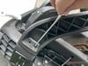 Instale os apoios de braço utilizando dois parafusos em cada um