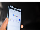 Uma fotografia de uma mão segurando um smartphone com a página inicial da Pesquisa Google aberta na tela. (Fonte da imagem: Solen Feyissa no Flickr)