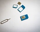 Cartões SIM em três tamanhos e um pino ejetor sobre uma superfície branca