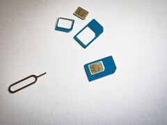 Cartões SIM em três tamanhos e um pino ejetor sobre uma superfície branca