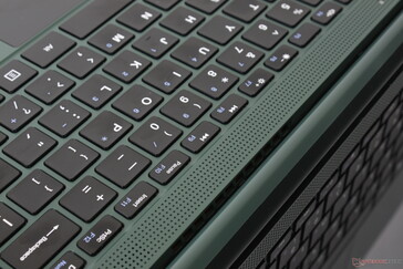 Grelhas dos alto-falantes acima da primeira fileira de teclas do teclado