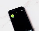 Smartphone sobre uma mesa branca exibindo o aplicativo WhatsApp