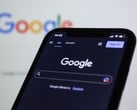 Smartphone mostrando a página de pesquisa do Google em frente a uma tela com o logotipo do Google