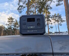 Bluetti Elite 100 V2 Bio-based em um teto de carro com pinheiros ao fundo