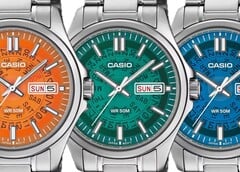 Três relógios Casio MTP-E740 nas cores laranja, azul-petróleo e azul brilhante, exibidos lado a lado com mostradores translúcidos que revelam os mecanismos de dia e data por baixo.