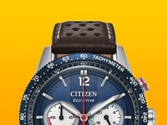 Close-up do Citizen Racing Chronograph CA4716-09L, mostrando seu aro taquimétrico azul, mostrador azul escuro com ponteiros e marcadores prateados, três submostradores, ponteiro central dos segundos vermelho e pulseira de couro perfurada marrom sobre um fundo amarelo.