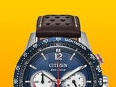 Close-up do Citizen Racing Chronograph CA4716-09L, mostrando seu aro taquimétrico azul, mostrador azul escuro com ponteiros e marcadores prateados, três submostradores, ponteiro central dos segundos vermelho e pulseira de couro perfurada marrom sobre um fundo amarelo.