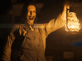 Uma figura sinistra segurando uma lanterna dá a entender os horrores que estão por vir na série The Conjuring (Fonte da imagem: Warner Bros)