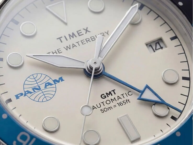 Close-up do relógio Timex Pan Am Waterbury Automatic GMT, mostrando seu mostrador branco-prateado, marcadores de horas luminosos, janela de data e a marca Pan Am.