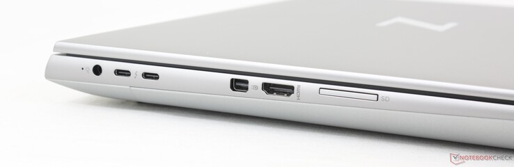 Esquerda: adaptador CA, 2x USB-C 3.2 Gen. 2 com Thunderbolt 4 + DisplayPort 1.4 + DisplayPort 1.4, mini-DisplayPort 1.4, HDMI 2.1, leitor de cartão SD. Observe as portas USB-C e do adaptador CA bem compactadas