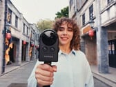 Mulher caminha pela rua filmando com a Portalcam