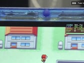 Imagem em detalhe do console portátil FPGBA SP azul-transparente rodando Pokémon, com um contador de 59.74 FPS visível.