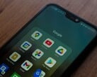 Smartphone sobre uma mesa de madeira com uma pasta do aplicativo Google aberta