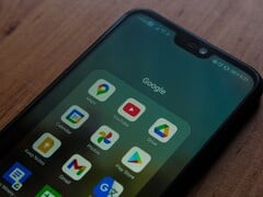 Smartphone sobre uma mesa de madeira com uma pasta do aplicativo Google aberta