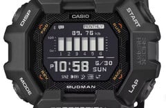 Relógio Casio G-Shock Mudman GDG-B100 com visor digital vermelho e branco diante de uma paisagem montanhosa acidentada.