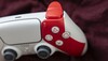 Uma faixa vermelha no punho e no ombro direito presta homenagem à tatuagem ômega de Kratos. (Fonte da imagem: PlayStation)